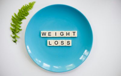 Image of a blue plate with the words "weight loss" spelled out on it.