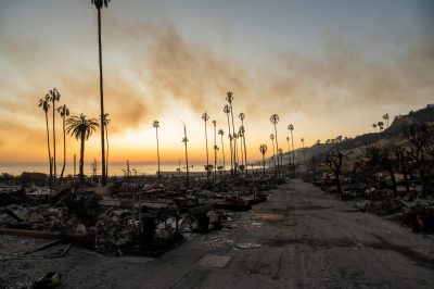 Sun setting on the Palisades Wild Fire on Jan. 11, 2025. Fire is still burning amid ashes and rubble